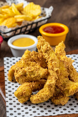 Panko covered fried chicken pieces with sauce and french fries.