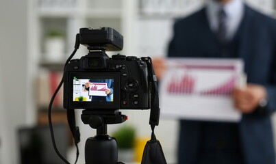Male in suit and tie show stats graph pad making promo videoblog or photo session in office camcorder to tripod closeup. Vlogger selfie sale solution or finance advisor management information © H_Ko
