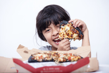 Happy little girl is holding slice of pizza on a white background