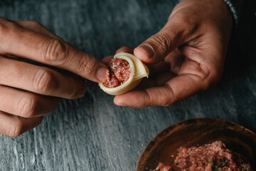man filling a Catalan galet with raw ground meat - obrazy, fototapety, plakaty