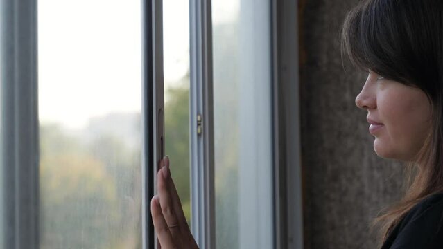 Portrait dreamy nice woman. Opens window with hand and looks out, take deep breath fresh air at morning, closes eyes with pleasure, dreams future. Gentle free look attractive female. Rest after work