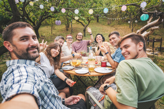 Group of friends having a backyard barbecue party, having fun taking selfies. Commubity and friendship concept