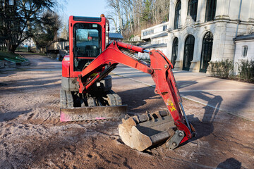 Small red excavator. Construction excavator in a construction site.