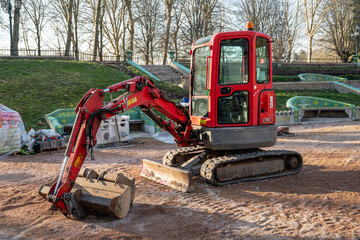 Small red excavator. Construction excavator in a construction site.
