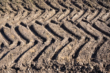 Tractor tire track in a dirt road. Tractor tire track. old tire track on a path. Close-up of wheel track on a dirt road