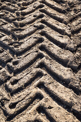 Tractor tire track in a dirt road. Tractor tire track. old tire track on a path. Close-up of wheel track on a dirt road