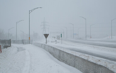 Road under the snow. Urban landscape in winter. City of Montreal under the snow. Winter storm in...