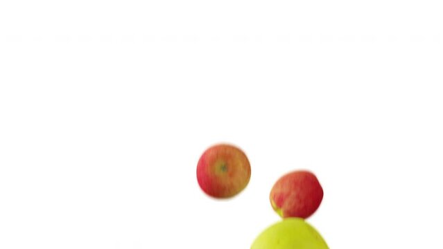 Green and red apples falling down in slow motion on white background.