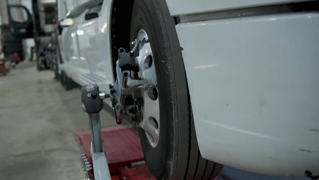 A truck stands on a truck wheel alignment stand in a repair shop. Close up