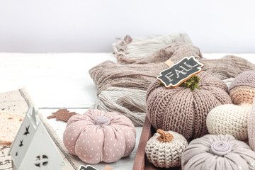 Fototapeta na wymiar Cozy autumn mood composition. Handmade decor for home, traditional fall symbols - knitted props