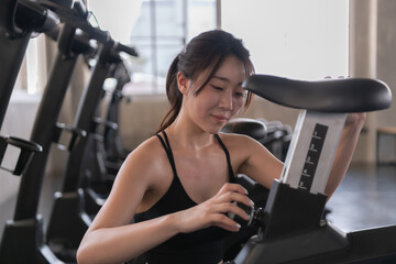 Fototapeta na wymiar Asian woman preparing exercise equipment in the gym.