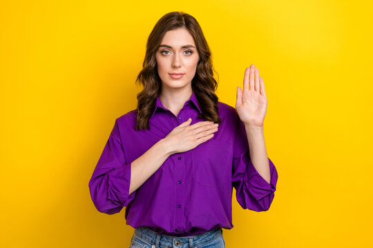 Photo of lovely calm young person arm touch heart raise palm swear promise isolated on yellow color background