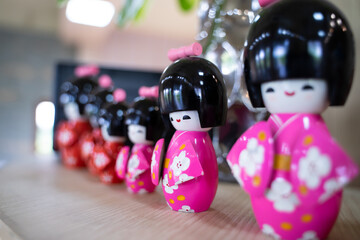 Cute, colorful Japanese-style ceramic dolls are lined up on the table to decorate your home