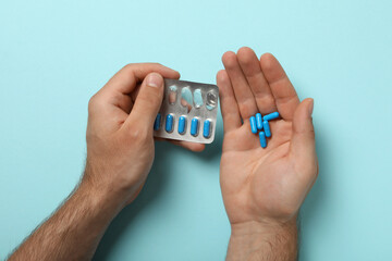 Blue viagra pills in a man's hand - obrazy, fototapety, plakaty