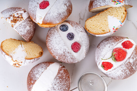Homemade italian sweet Maritozzi buns, breakfast dessert brioche stuffed with whipped cream, with various topping, nuts, fruit 