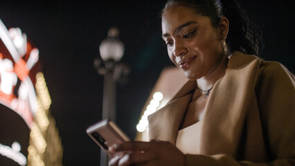 Portrait of attractive female using her phone out in the icy at night