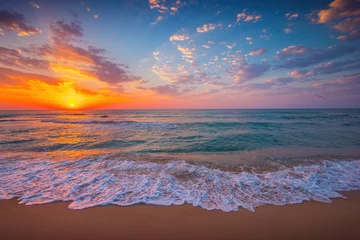 Fototapeten Tropical sunrise over ocean waves and beach shore, sea horizon  nature landscape © ValentinValkov