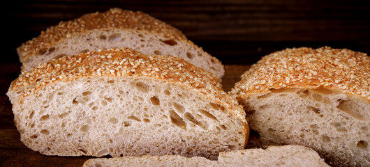 Ciabatta bread. Sliced pieces of bread on a wooden background.