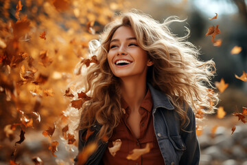 Young pretty blonde woman having fun with fallen autumn leaves in a park. travel and tourism, marketing campaign.