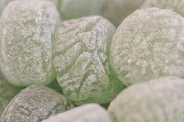 Green menthol candies thrown into a bowl.