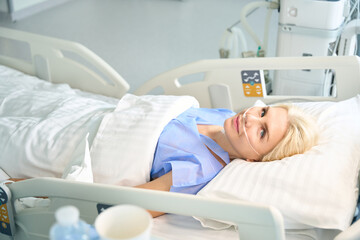 Beautiful woman after surgery lies in room with modern equipment