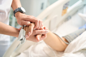 Attending physician holds the patients hand