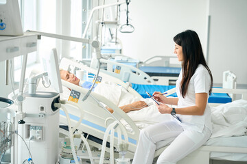 Doctor records the vital signs of the patient