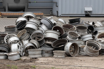 Old Car Rims Pile at Scrapheap Junkyard. Stack of old discarded wheels, metal recycling industry.