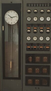 Old pendulum clock, amperage meter, vintage ammeter, instrument to measure time and electricity in industrial setting, Vertical video 4k
