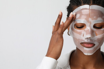 Portrait of young woman applies a hydro gel face mask. Skin care and beauty.
