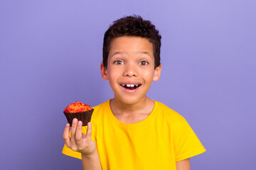 Photo of excited cute boy wear trendy clothes hand hold delicious baked cookie isolated on purple...