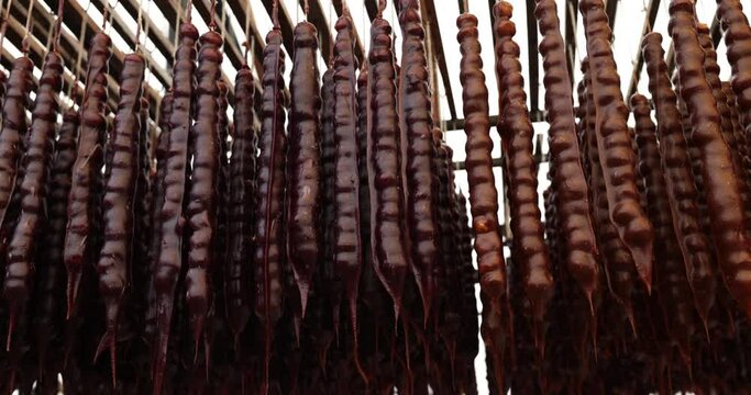 Churchkhela hanging in clusters at food market closeup. Traditional Georgian national delicacy