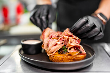 chef Cooking of beef tongue with potatoes and mushroom sauce at the restaurant kitchen