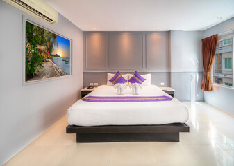 Hotel Room Decorated single double bedroom with nice white bed sheets purple decorative colours. the colour scheme is designed for thailand and interior is m modern classical