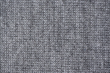macro texture of gray woolen sweater, close up of light gray knitted fabric piece, winter woolen piece of crocheted fabric as background, gray knitted fabric swatch  