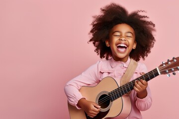 Joyful child playing guitar isolated on pink background with copy space. Creative banner for children music school. - obrazy, fototapety, plakaty