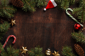 Xmas and New Year background. Frame composition made of fir branches, pine cones, candy canes and Christmas decorations. Overhead view with copy space. Creative layout - Powered by Adobe