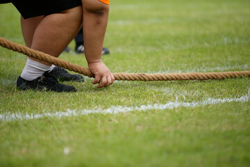 The fat hand start to hold the rope of Tug od war.Stong at the playyard on sports day at the school.