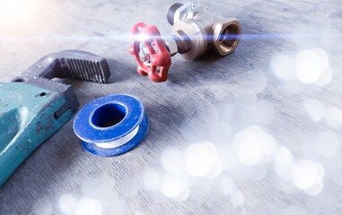Close up the pipe wrench , rotary valve and sealtape on the wood table ,  plumbing services...