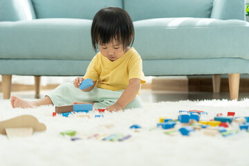 Happy Asian child playing and learning toy blocks. children are very happy and excited at home. child have a great time playing, activities, development, attention deficit hyperactivity disorder.