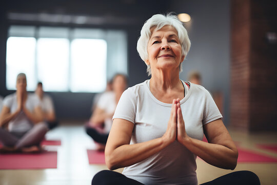 Elderly woman doing yoga in a fitness club