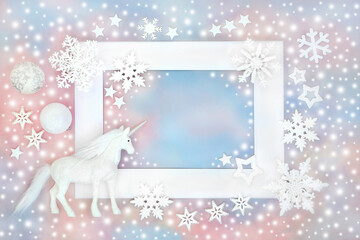 Christmas unicorn, snowflakes and white bauble decorations on blue pink sky background white frame. Festive design for greeting card, gift tag, label, invitation.
