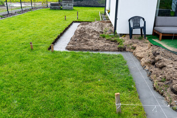 Foundation footings poured in a ditch in the yard, building a terrace in the backyard.