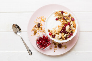 Healthy breakfast food with granola, yogurt, fruits and nuts. Dessert parfait with dried fruits for breakfast