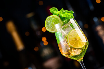 Hugo spritz cocktail drink with sparkling wine, elderflower syrup, soda, lime, mint and ice, dark...