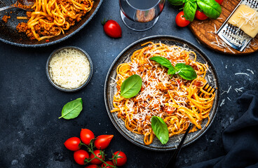 Spaghetti bolognese or pasta with minced meat in tomato sauce with green basil and chianti red wine...