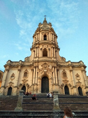 Fototapeta na wymiar The majestic facade of the San Giorgio Cathedral in Modica stands tall against the sky. This Sicilian Baroque masterpiece captivates with its rich ornamentation and architectural grandeur.