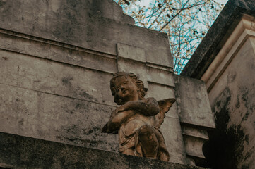 sculpture of an angel in ruins in abandoned cemetery