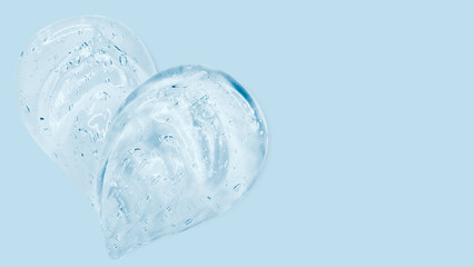 Drops and smears of a transparent gel or serum on a blue background. Banner with empty space for advertising.