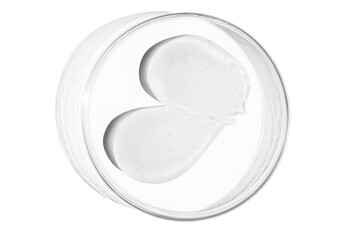 Petri dish with a drop and a smear of a transparent gel or serum on an empty background.